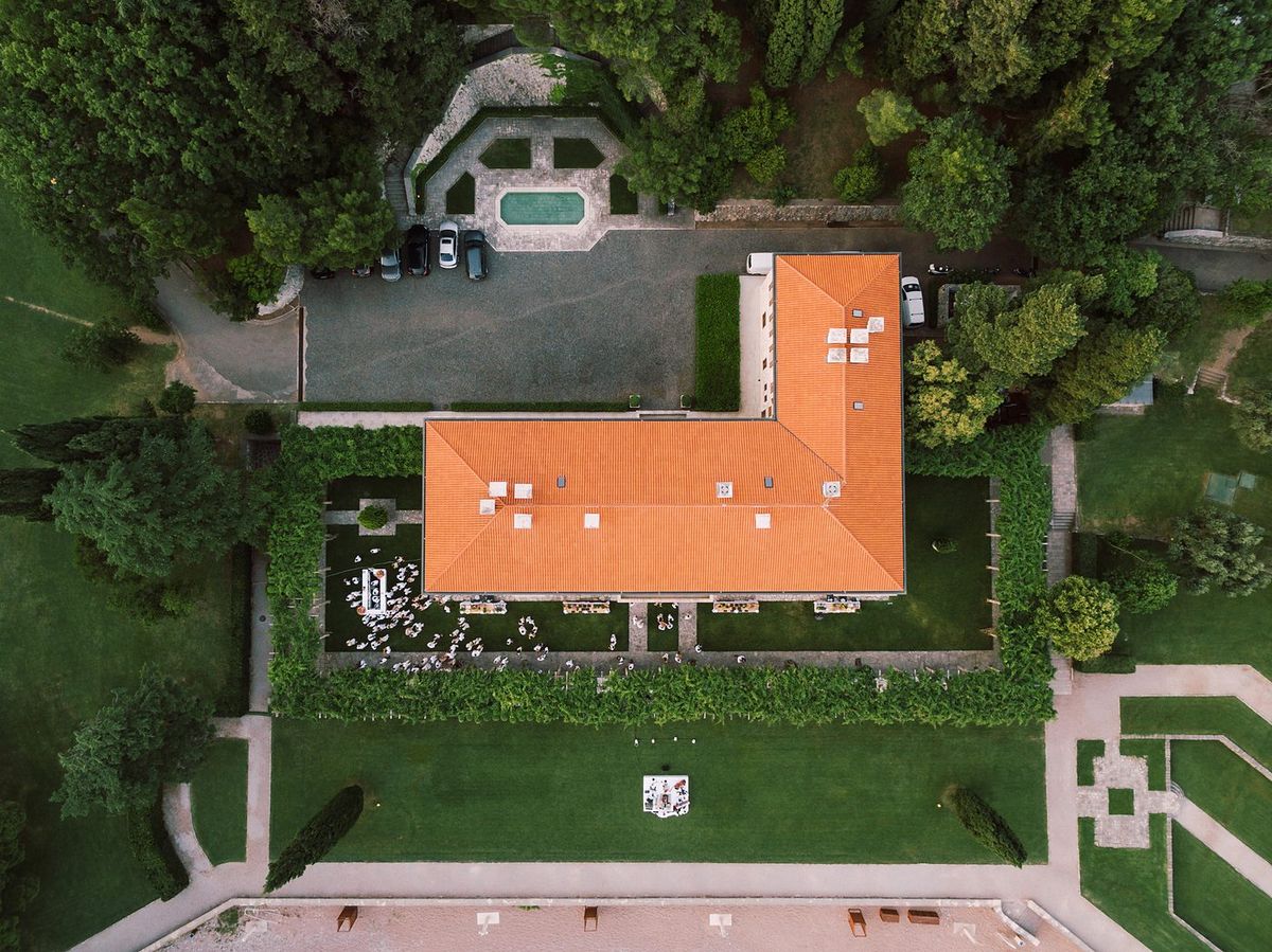 Drohnenaufnahme einer Eventlocation mit Garten und gedeckter Hochzeitstafel