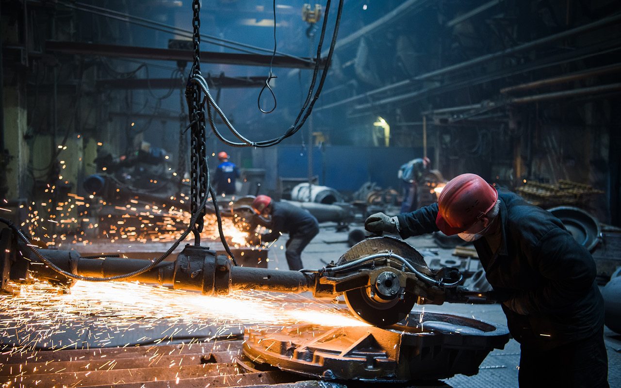 Industrial photography for companies and production: worker cutting with an angle grinder and flying sparks