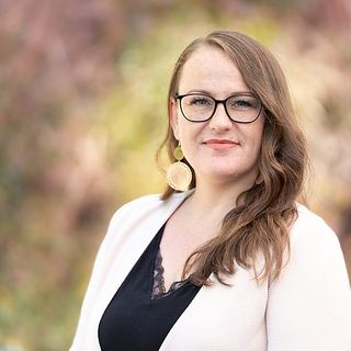 Business Portrait Saarland: Frau mit Brille vor herbstlichem Hintergrund im Freien
