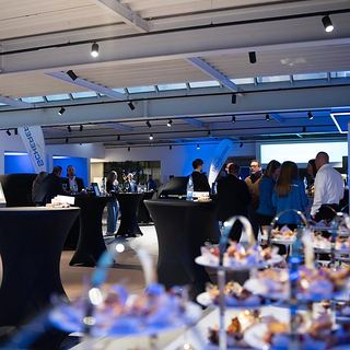Eventfotografie Saarland: Gäste an Stehtischen bei einer Abendveranstaltung im Autohaus