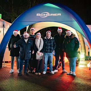 Eventfotografie Saarland: Team eines Autohauses mit Weihnachtsmützen vor dem Eventzelt