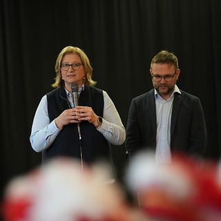 Eventfotografie Saarland: Rednerin mit Mikrofon auf der Bühne bei einer Jubiläumsfeier