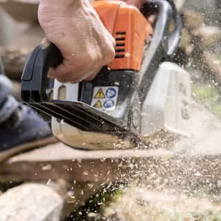 Werbefotografie Saarland: Kettensäge im Einsatz mit fliegenden Holzspänen