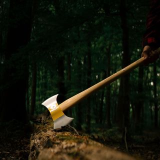 Werbefotografie Saarland: Axt im Baumstamm im dunklen Wald