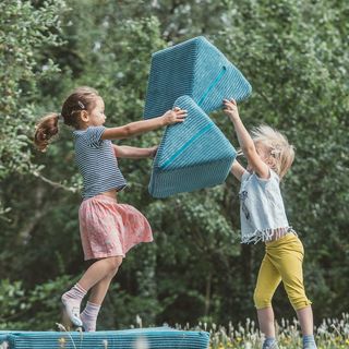 Werbefotografie Saarland: Kinder bauen mit Spielpolstern im Garten