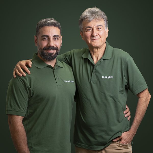Business Portrait Saarland: Zwei Mitarbeiter einer Praxis im Teamportrait vor grünem Hintergrund