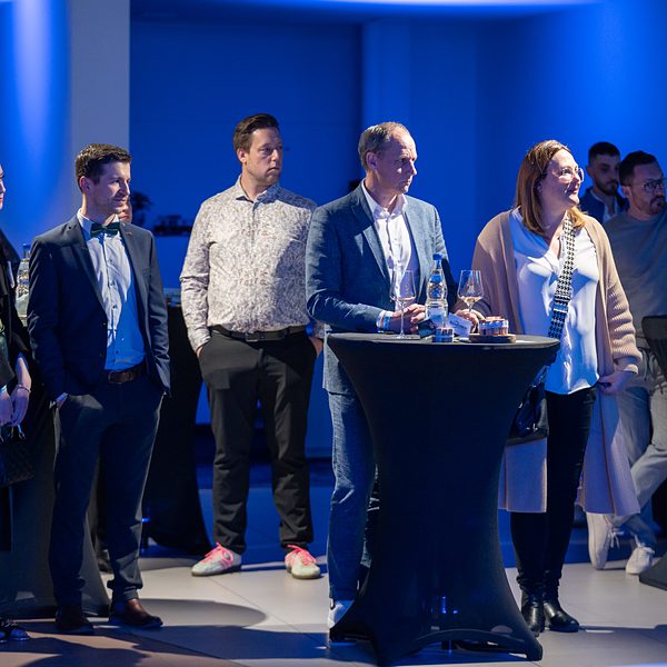 Eventfotografie Saarland: Gäste an Stehtischen in blauem Licht bei einer Präsentation