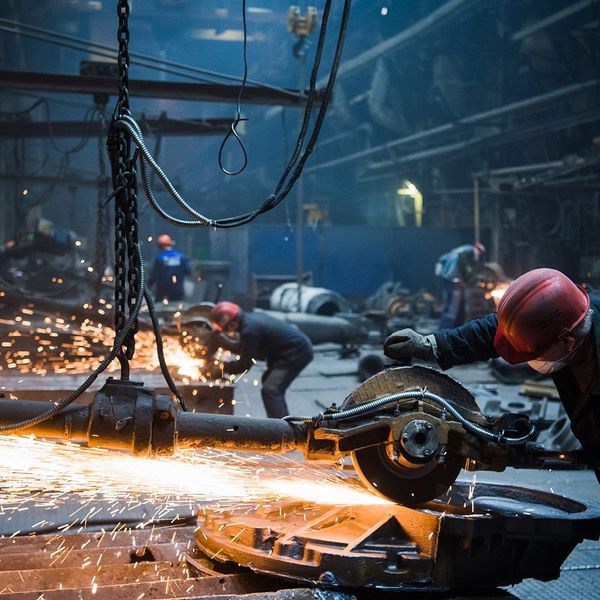 Industrial photography Saarland: worker cutting with an angle grinder and flying sparks