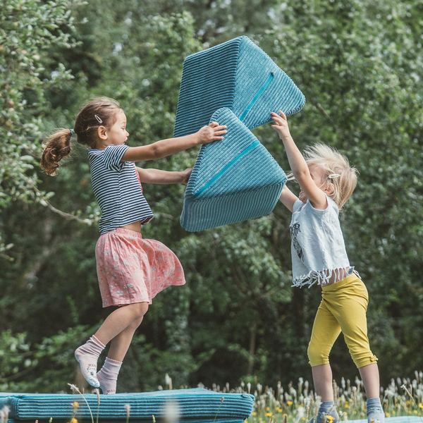 Werbefotografie Saarland: Kinder bauen mit Spielpolstern im Garten