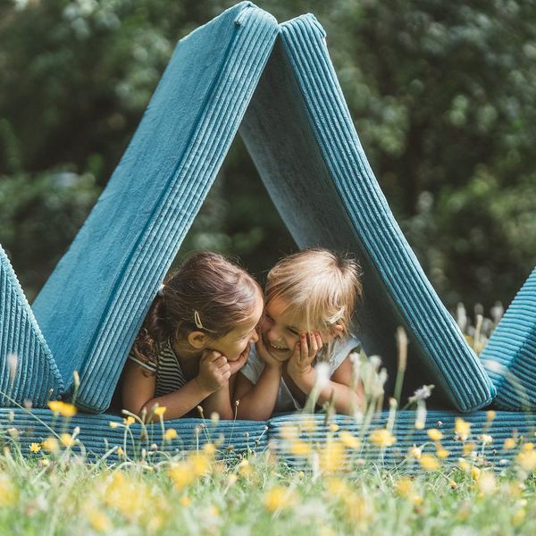 Werbefotografie Saarland: Kinder mit Spielpolstern auf einer Blumenwiese