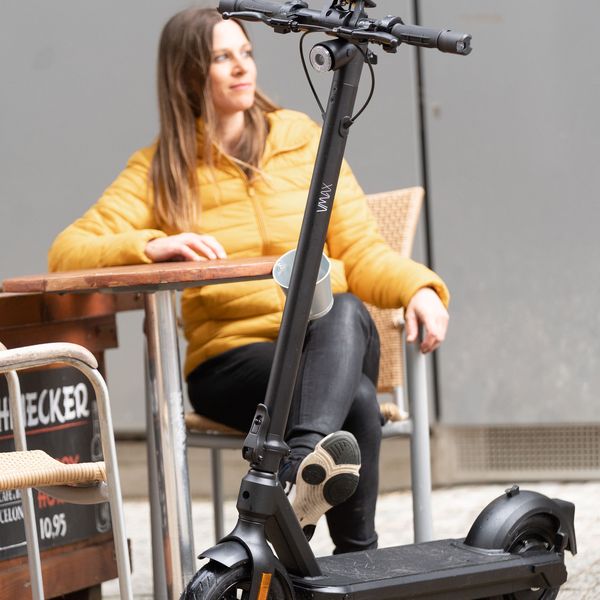 Werbefotografie für VMAX: Frau mit E-Scooter vor einem Café
