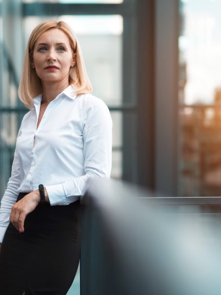 Portrait of a serious business lady female worker near office building